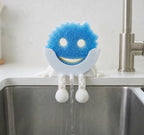 Kitchen Sponge Holder with Articulated Dangling Legs and a Front Drainage Spout for Sink-Side Storage